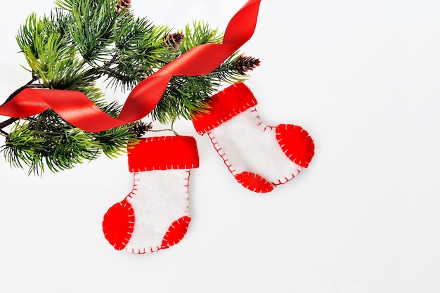 Botas do Papai Noel na árvore de natal e fita vermelha