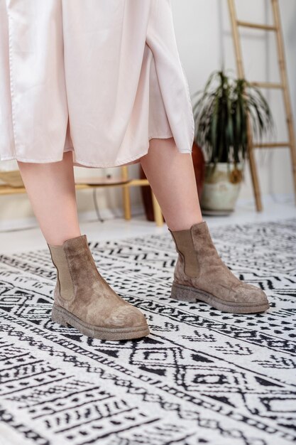 Botas femininas de camurça de couro bege de outono com belas pernas. sapatos femininos elegantes feitos de materiais naturais