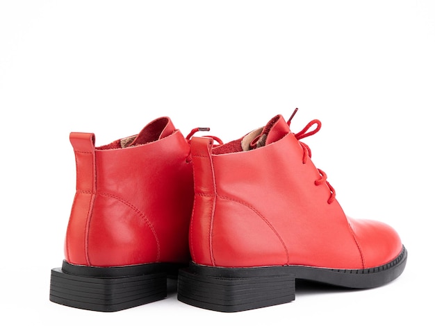 Botas femininas de couro vermelho de outono com sola preta isoladas em fundo branco vista lateral