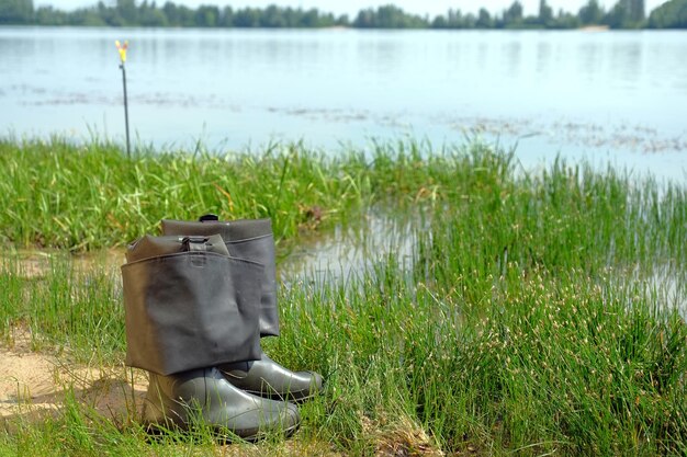 Botas de goma de pesca a orillas del río concepto de pesca