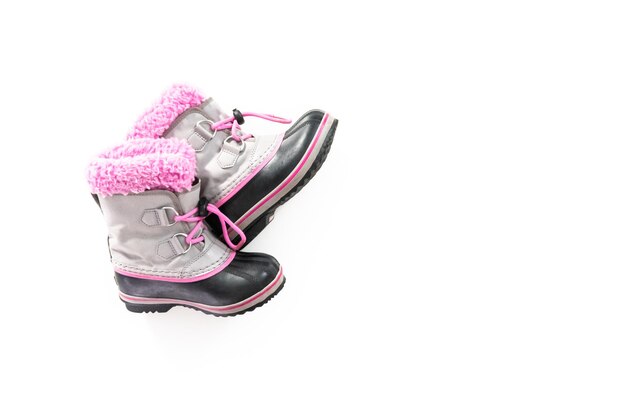 Foto botas de invierno cálidas e impermeables de color rosa y gris para niña sobre un fondo blanco.