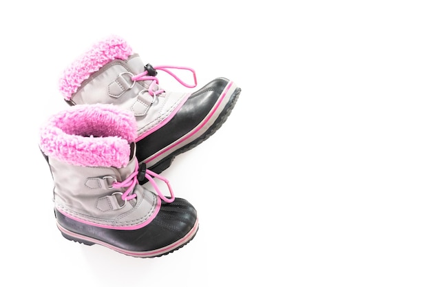 Botas de invierno cálidas e impermeables de color rosa y gris para niña sobre un fondo blanco.