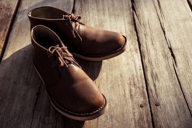 Foto botas marrones elegantes sobre suelo de madera