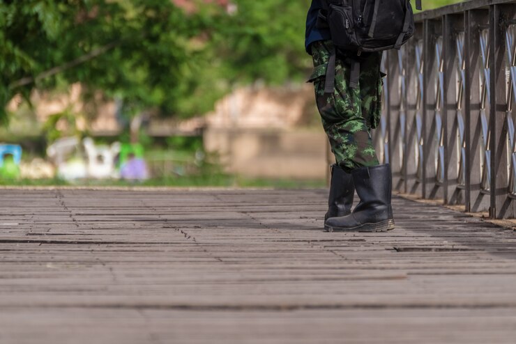 Botas militares caminando por un puente de madera