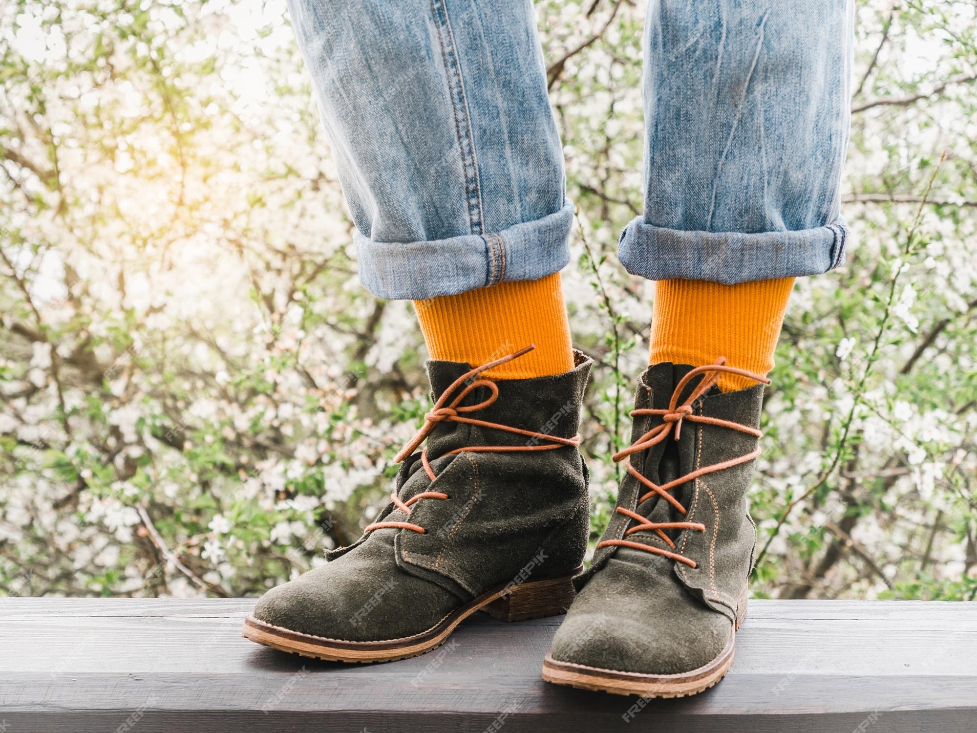 Botas moda y calcetines coloridos en el fondo de un árbol en flor primer plano al aire libre luz del día estilo de hombres y mujeres concepto de belleza y elegancia