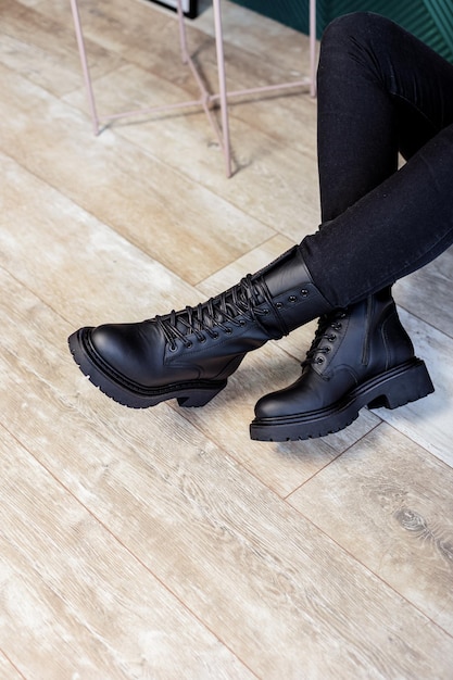 Botas de mujer en piel negra de la nueva colección. Piernas de mujer con elegantes botas de cuero otoño-invierno.
