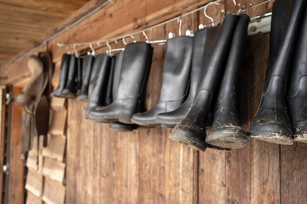 Botas pretas de borracha impermeável que podem ser alugadas penduradas em prendedores de roupa