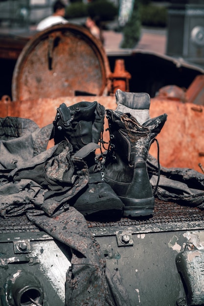 Botas queimadas e peças de roupa de um soldado russo em veículo blindado acolchoado na guerra na Ucrânia