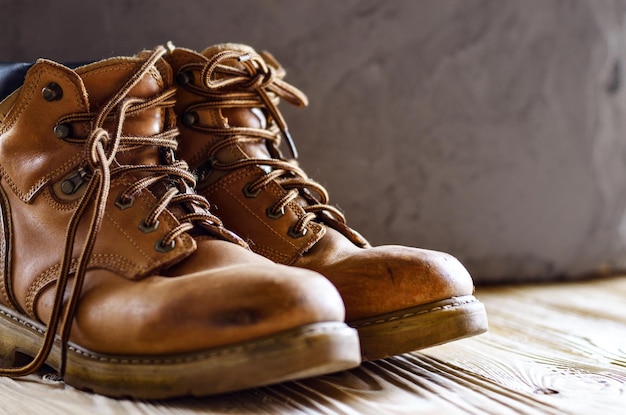 Botas de trabajo usadas de cuero amarillo en primer plano de fondo de hormigón. lugar para texto