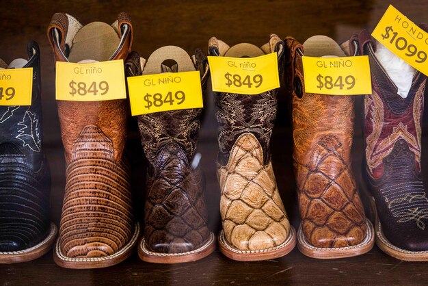 Botas de vaquero y cinturones de cuero en una vitrina de negocios calzado y accesorios de sillería