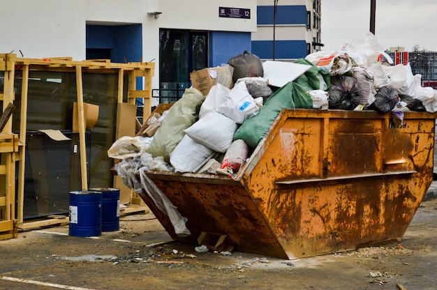 Foto bote de basura industrial de hierro grande un lío con basura con suciedad malas condiciones insalubres de seguridad