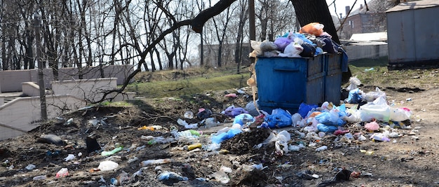 Foto el bote de basura está lleno de basura y desperdicios. eliminación prematura de basura en áreas pobladas