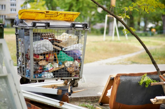 Foto bote de basura de metal lleno de basura en la calle basura pública al costado de la carretera