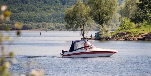 Un bote con motor flota a lo largo del río hasta la orilla