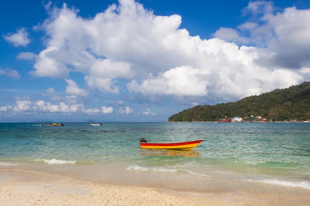 Bote pequeño cerca de la costa y cielo nublado.