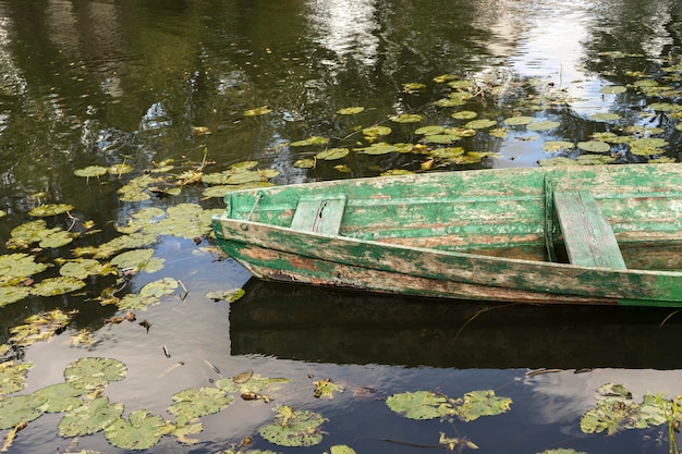 Bote de remos flotando sobre el lago lago de pesca a principios de verano