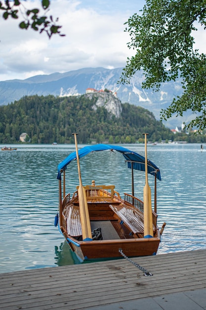 Bote de remos de madera amarrado en el muelle del lago bled