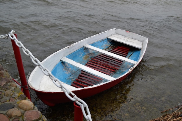 Bote de rescate en la orilla o viejo bote de pesca en el río