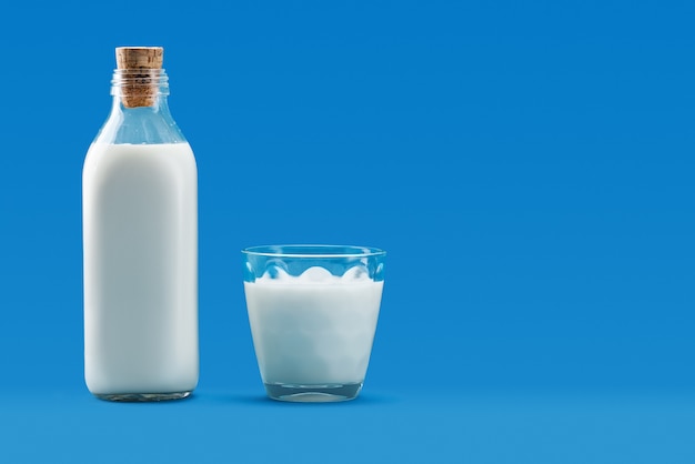 Foto botella abierta y un vaso de leche