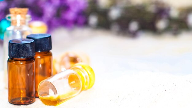 Botella de aceite esencial Botella de gotero de hierbas o aromaterapia aislada sobre fondo blanco Flores de romero frescas y aceites esenciales en la mesa