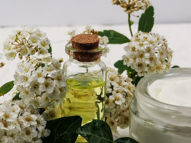 Botella de aceite esencial y frasco con crema.