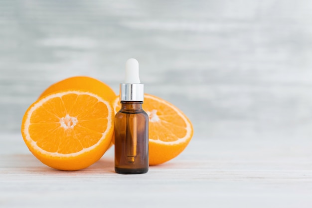 Botella con aceite esencial de naranja cítrica natural en madera