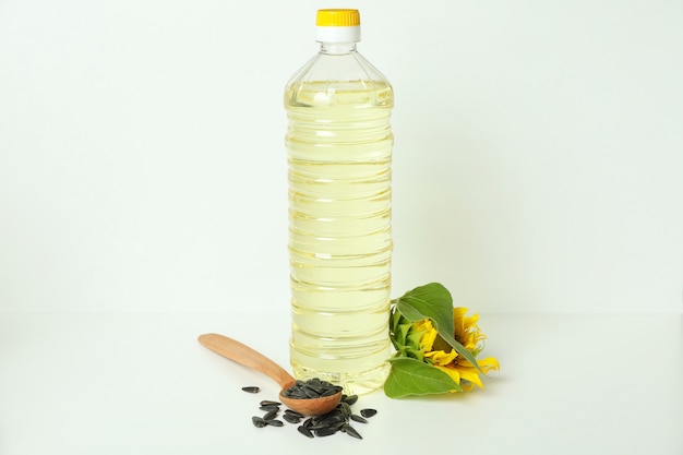 Botella de aceite de girasol e ingredientes sobre fondo blanco.