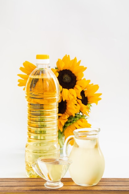 Botella de aceite de girasol con flor aislado sobre fondo blanco.