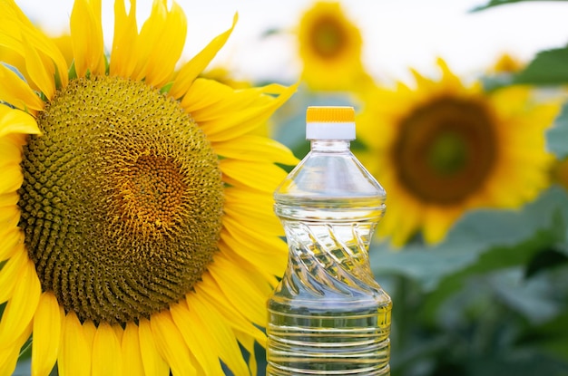 Una botella de aceite de girasol en el fondo de un campo de girasoles en flor