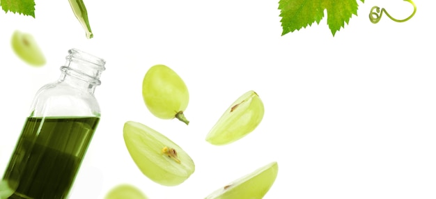 Botella con aceite de semilla de uva verde sobre fondo blanco.