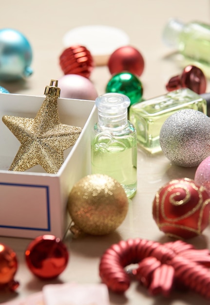 Una botella de adornos para el árbol de Navidad junto a una caja de adornos navideños.