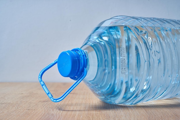 Una botella de agua con un asa azul que dice "agua"