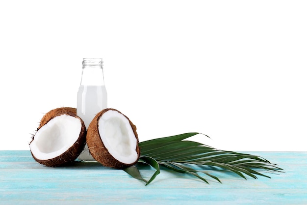Botella de agua de coco y nueces frescas sobre fondo blanco