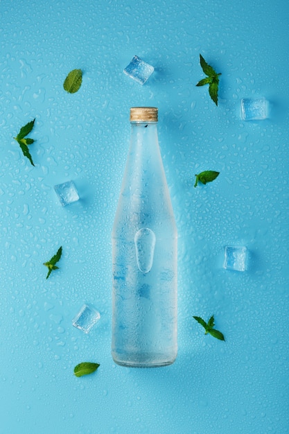 Botella de agua con cubitos de hielo y hojas de menta