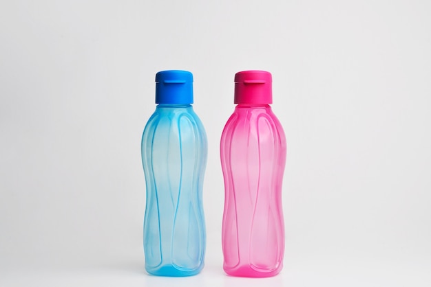Botella de agua deportiva Botellas de plástico de color agua Botella de agua líquida transparente de color Recipiente en fondo blanco aislado