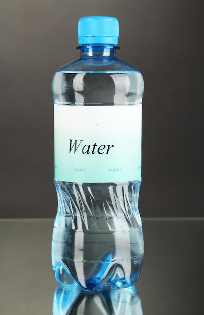 Botella de agua con etiqueta sobre fondo gris