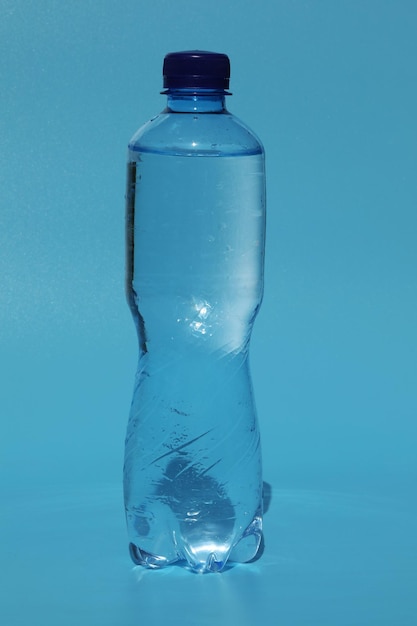 botella de agua fría sobre fondo azul