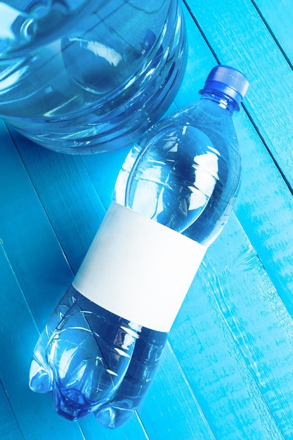 Foto botella de agua en la mesa de madera