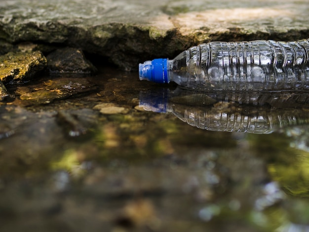 Foto botella de agua plástica vacía transparente flotando en el agua