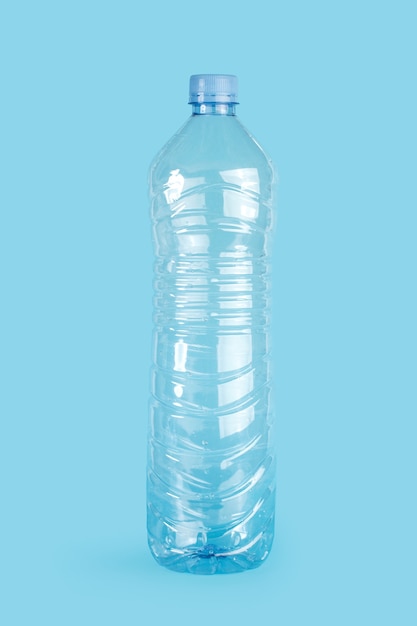 Botella de agua de plástico vacía sobre un fondo azul.