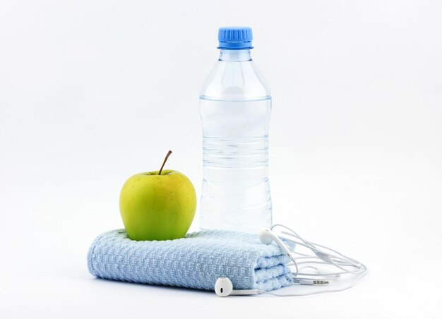 Botella de agua con toalla fitness y manzana