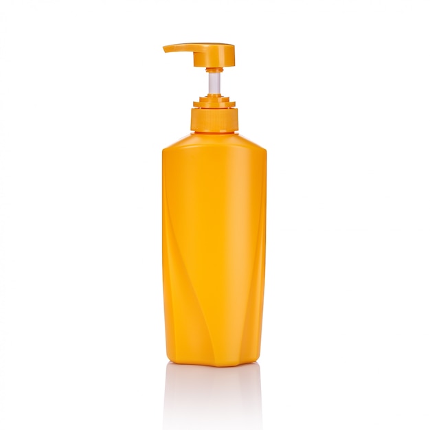 Botella de bomba de plástico amarillo en blanco utilizada para champú o jabón.