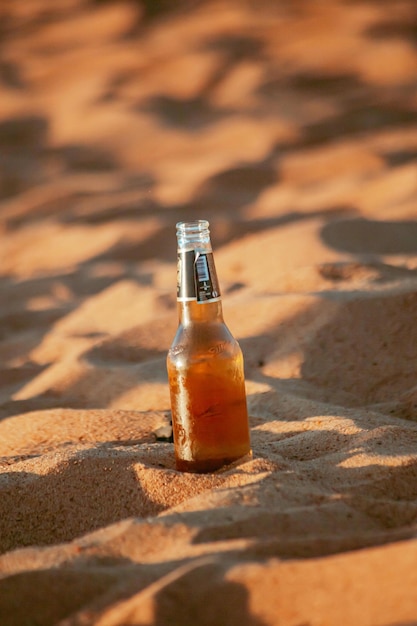 botella de cerveza en la arena de la playa