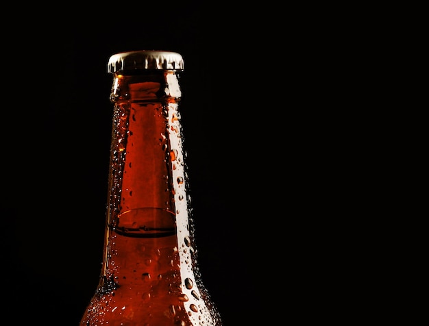 Botella de cerveza de cristal sobre fondo negro