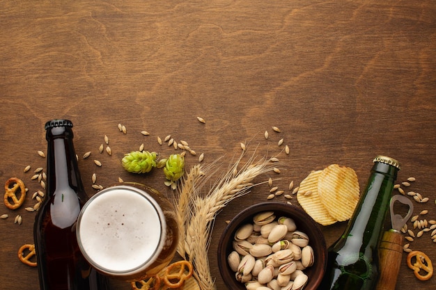 Botella de cerveza y diferentes bocadillos en la mesa de madera rústica Vista superior