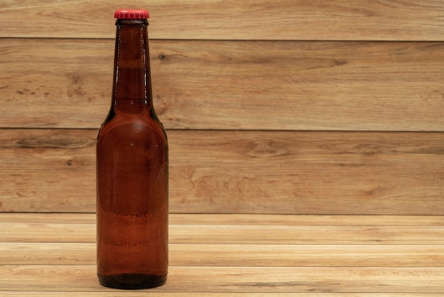 Foto botella de cerveza con fondo de madera