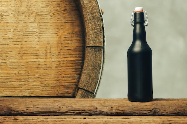 Botella de cerveza negra en una vieja mesa de madera Fondo del barril