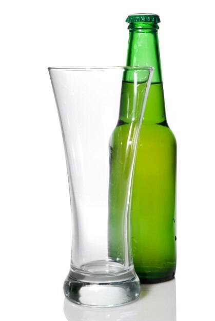 Botella de cerveza y vaso vacío aislado en blanco