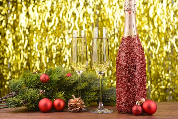 Botella de champagne con decoración navideña en superficie brillante