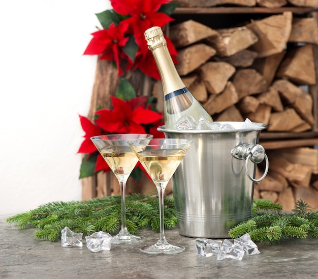 Foto botella de champagne y dos copas decoración navidad año nuevo flor de pascua roja